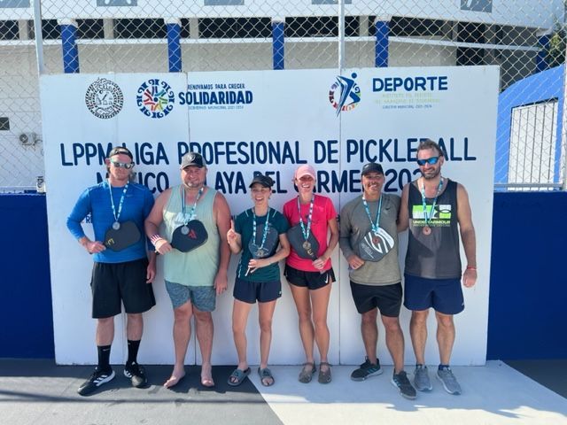 A group of people standing in front of a wall that says deporte