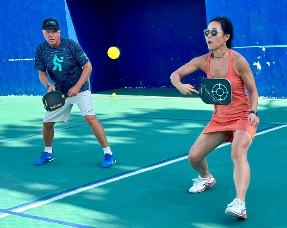 A man and a woman are playing pickleball on a court  at the Playa Del Carmen Pickleball Club in Playa Del Carmen, Mexico
