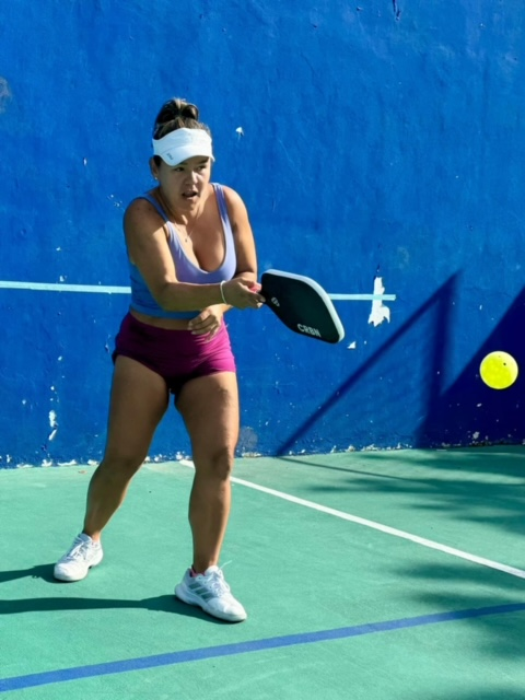 A woman is playing pickleball with a wilson racquet