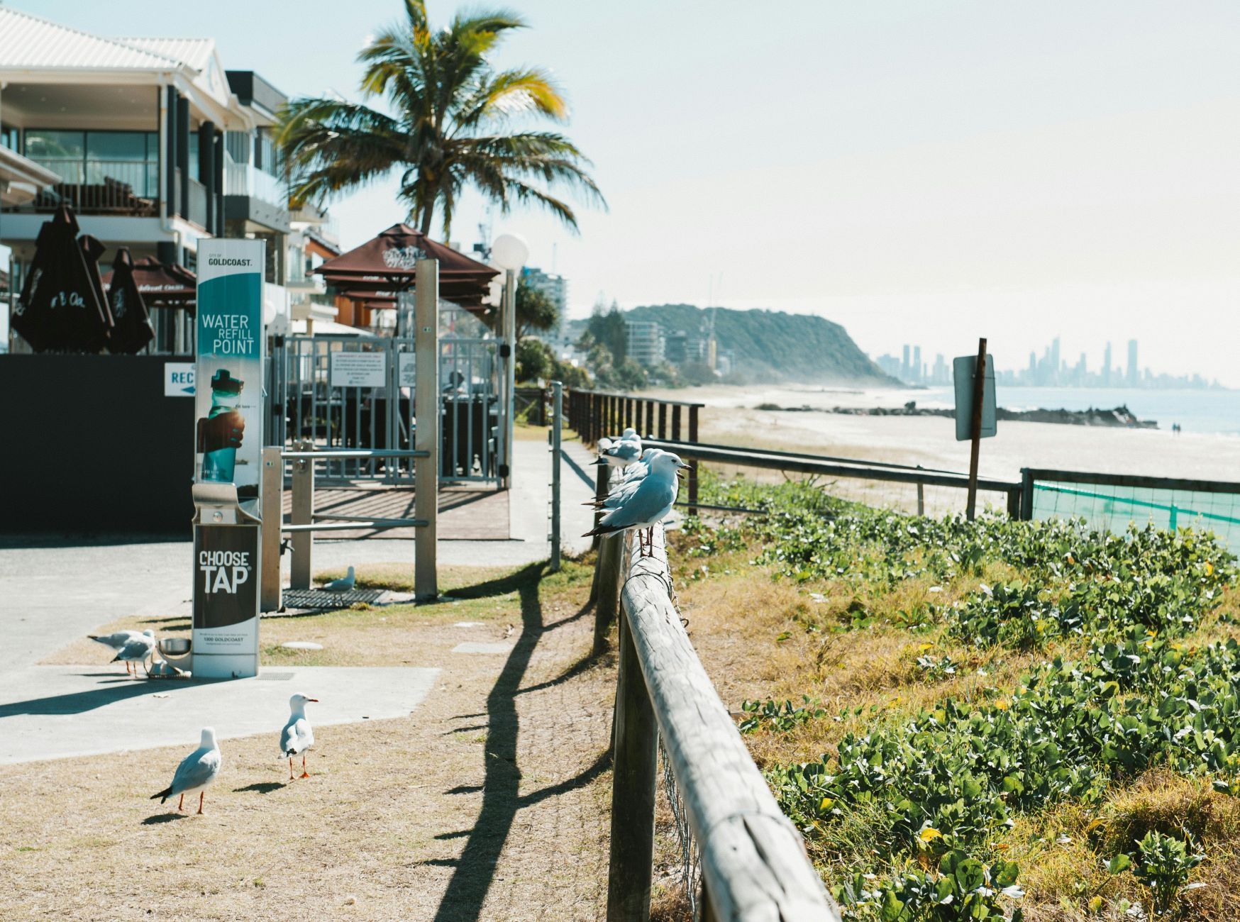View of beachside coast with cafes at the side.