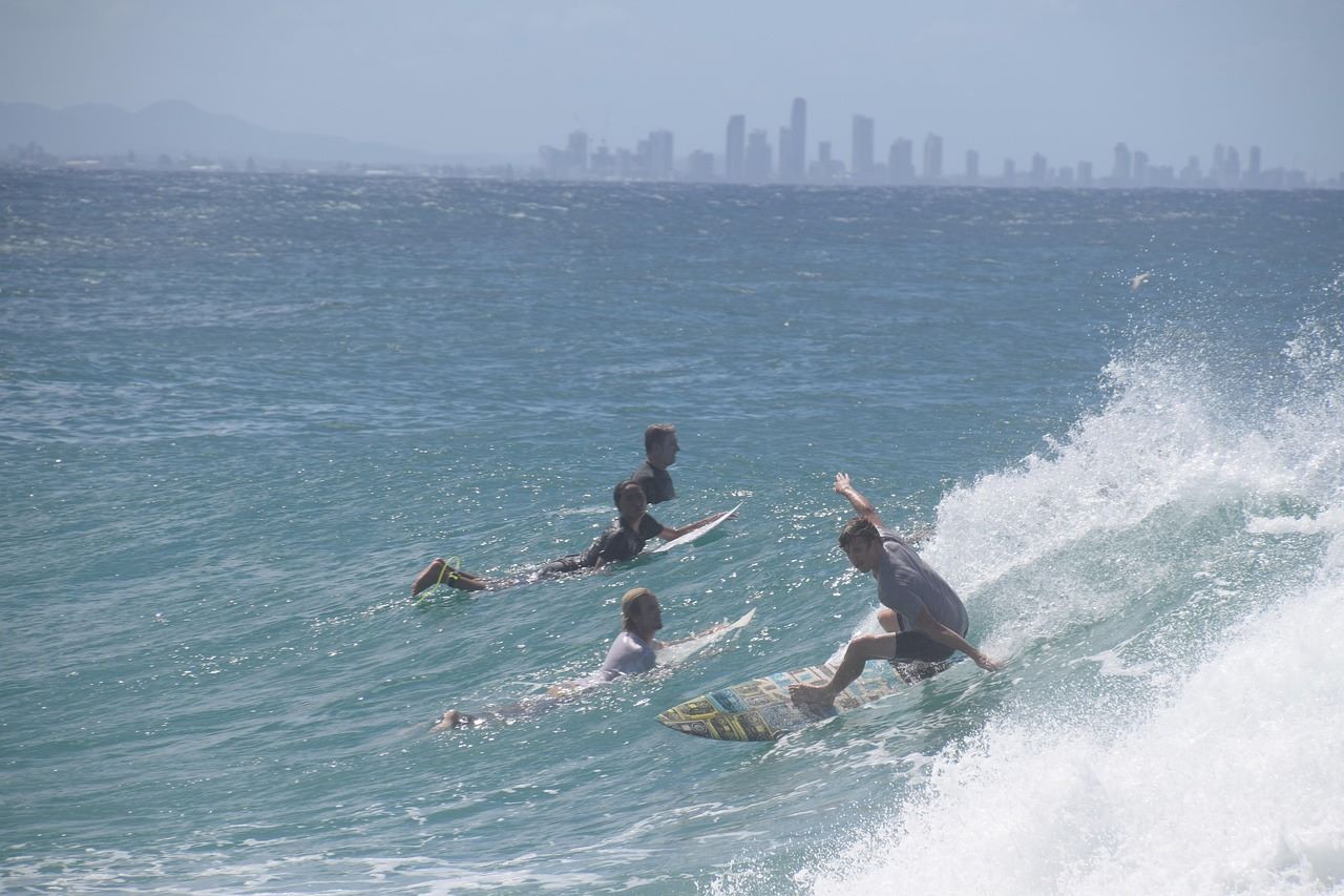 Surfers at Gold Coast beach. LM Edge brokers can help with loans for homebuying in Gold Coast.