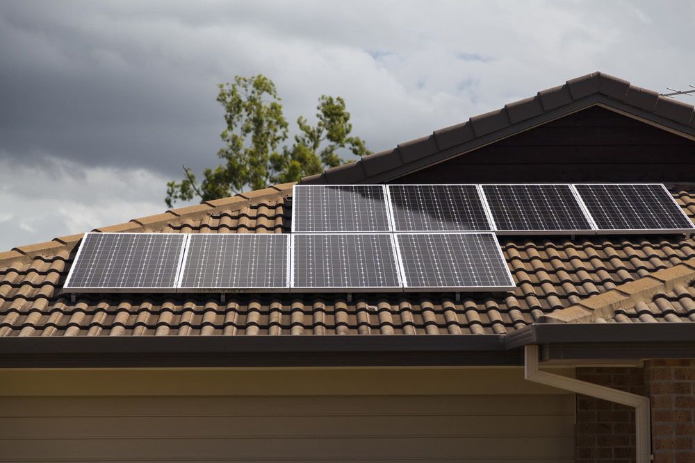 A Row of Solar Panels on the Roof of a House — Ray Smith Electrical in Korora, NSW