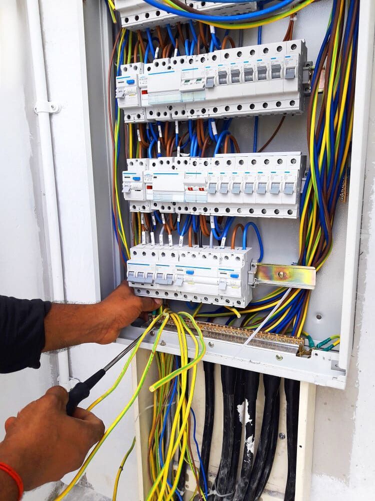 A Man is Working on an Electrical Box With a Screwdriver — Ray Smith Electrical in Korora, NSW