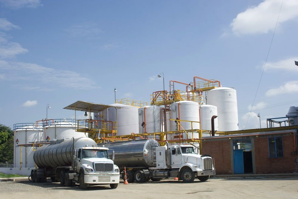 Two Tanker Trucks Are Parked in Front of a Factory — Ray Smith Electrical in Korora, NSW
