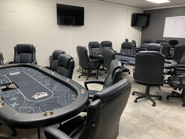 A room filled with tables and chairs and a television.