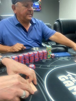 A stack of poker chips , dice , and playing cards on a table.