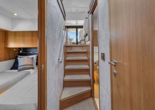 A hallway with stairs leading up to the second floor of a boat.