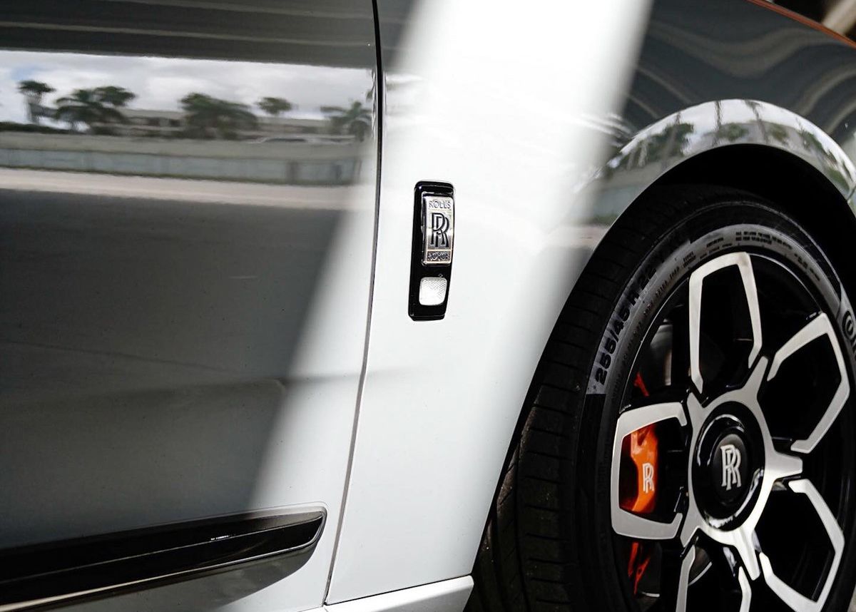 A close up of the side of a silver car.