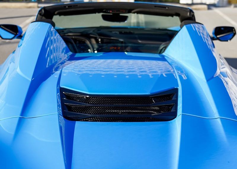 A close up of the hood of a blue sports car.