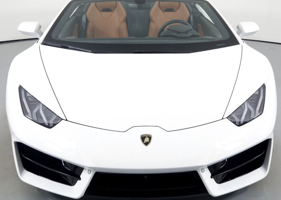 The front of a white Lamborghini Huracan with brown seats.