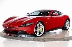 A red Ferrari is sitting on top of a white surface.