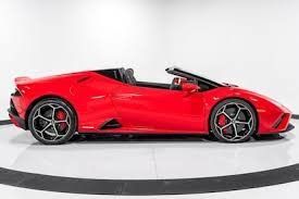 A red Lamborghini is parked on a white surface.