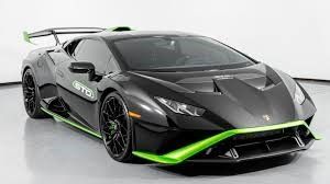 A black and green Lamborghini is parked on a white surface.