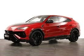 A red Lamborghini Urus is parked on a white background.