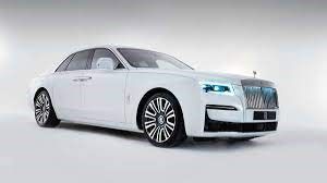 A white Rolls Royce Ghost is parked on a white surface.