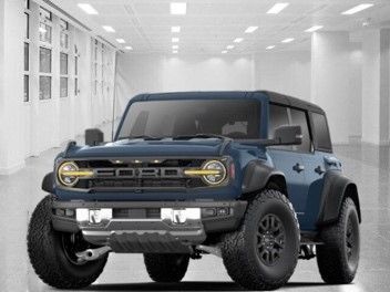 A blue Ford Raptor is parked in a garage.