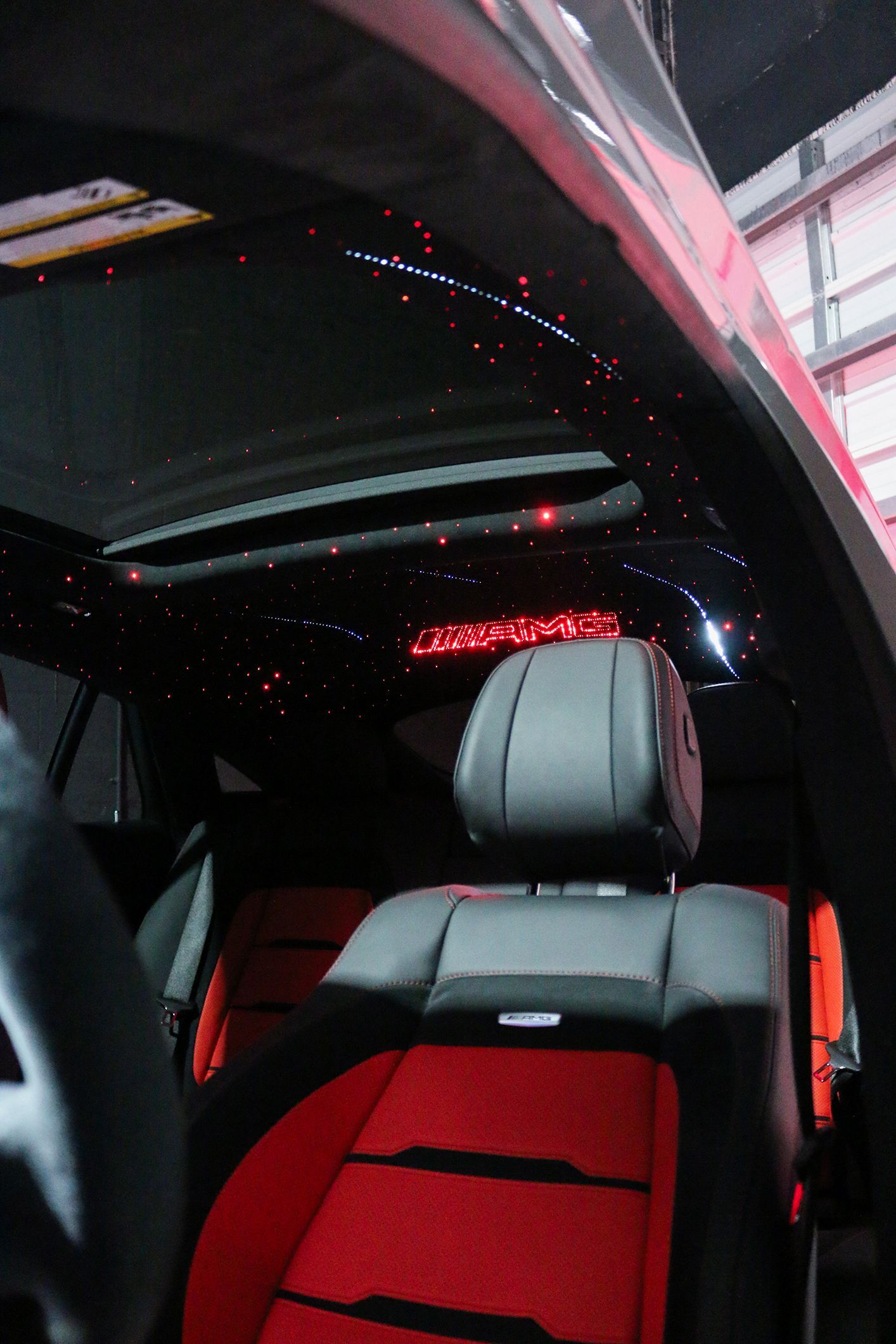 The inside of a car with red seats and a black roof