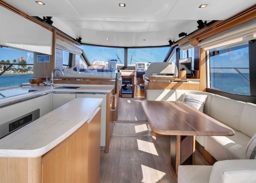 The inside of a yacht with a table and couch.