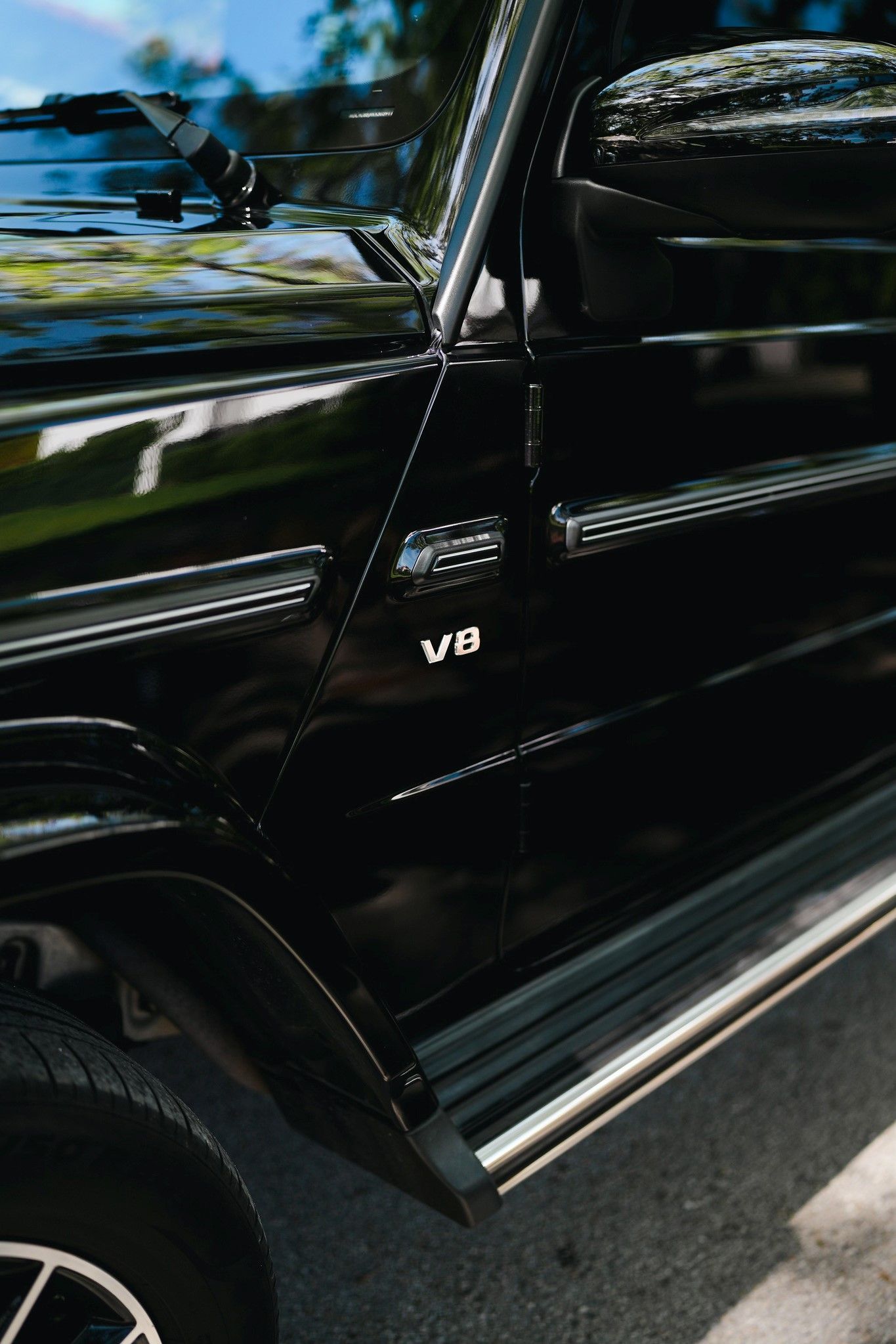 A close up of a black Mercedes Benz parked on the side of the road.