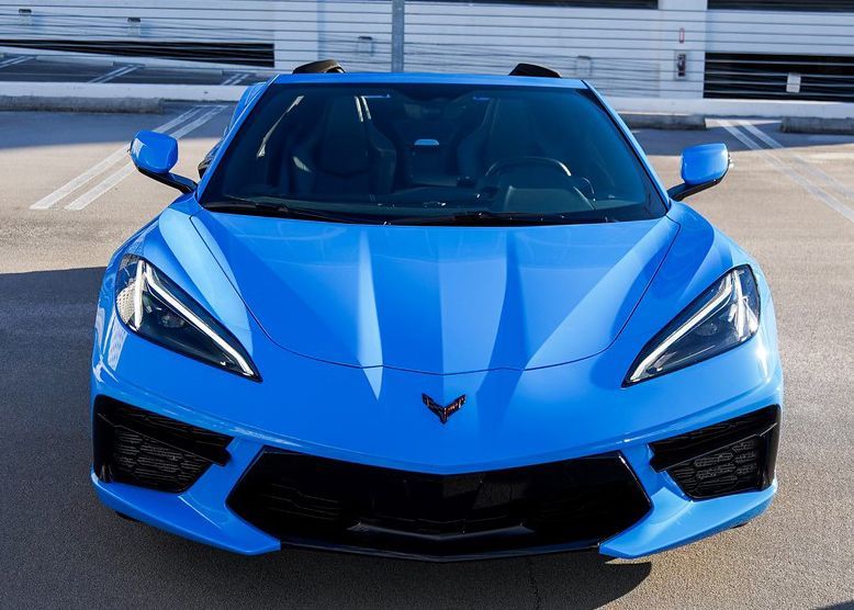 A blue Corvette is parked in a parking lot.