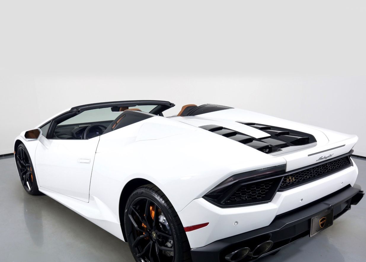 The rear end of a white Lamborghini Huracan is shown.
