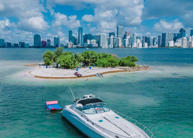 A boat is docked on a small island in the middle of the ocean.