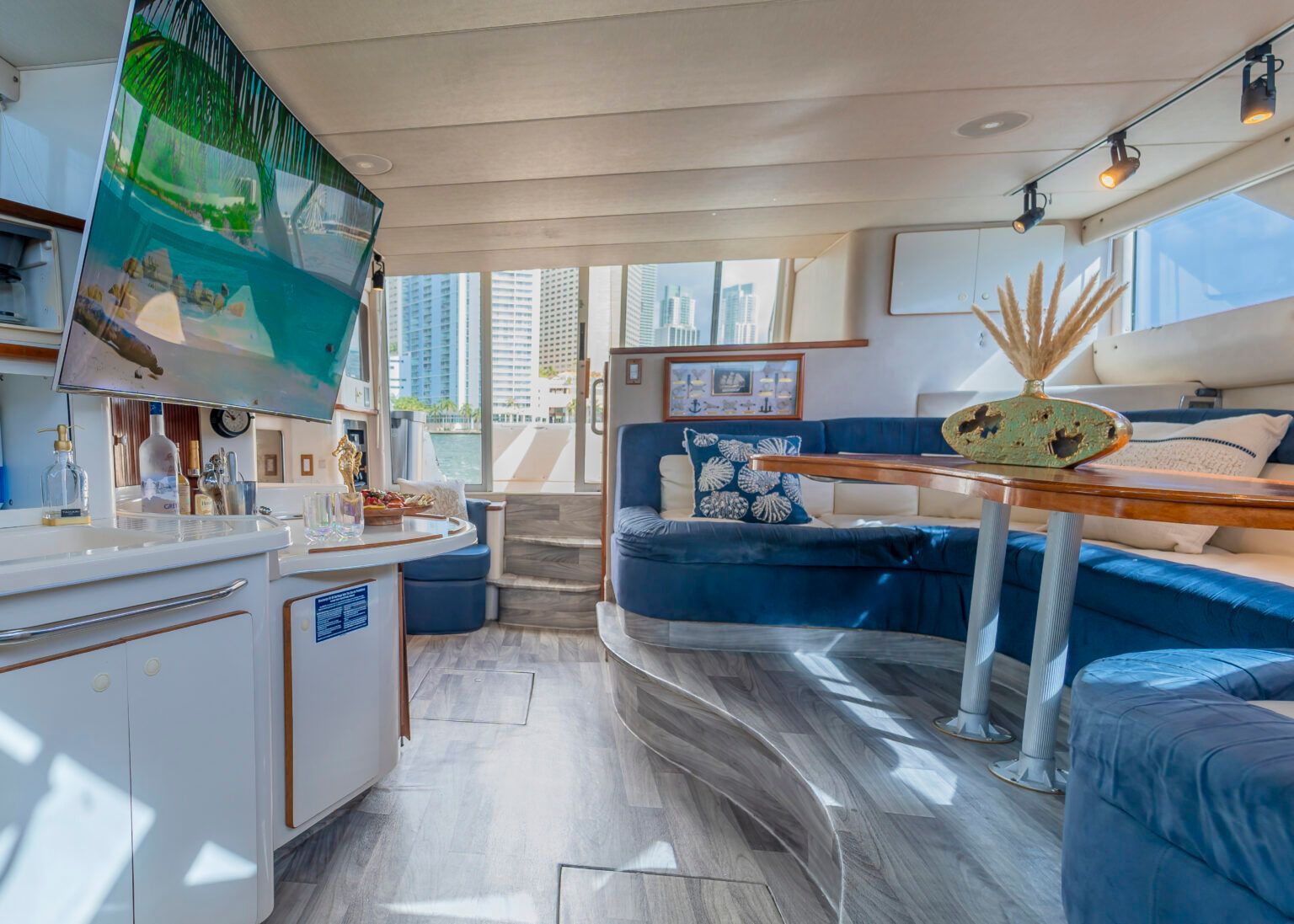 A living room on a boat with a couch, table, and television.