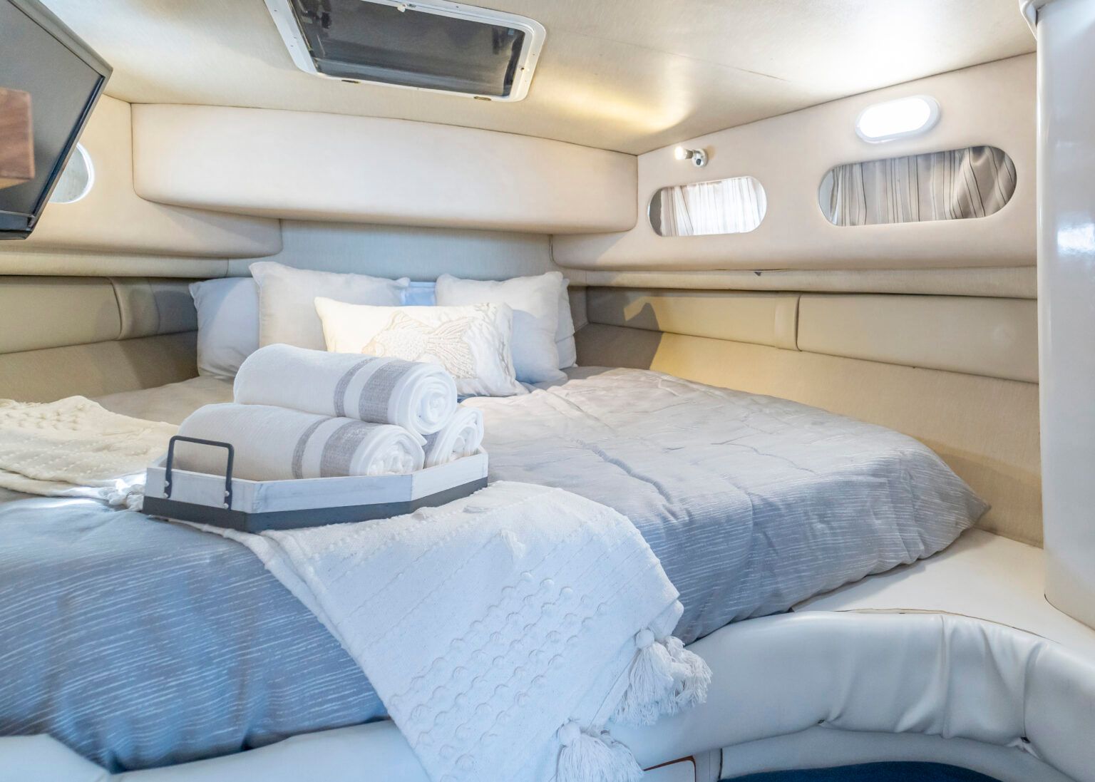 The inside of a boat with a bed and a television.