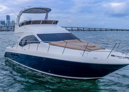 A white and blue yacht is floating on top of a body of water.