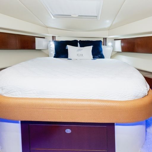 A bed on a boat with a blue pillow that says axx.