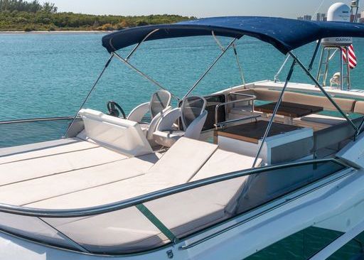 A boat with a blue canopy is floating on top of a body of water.