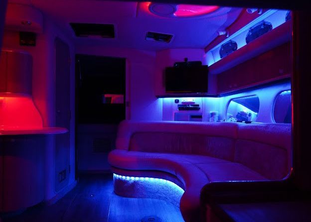 A room with purple and red lights on the walls and ceiling.