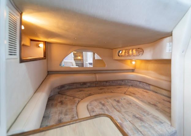 The inside of a boat with a couch and a table.