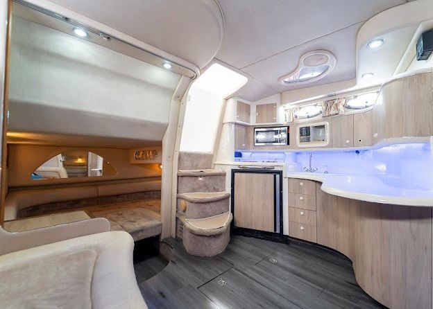 The inside of a boat with a kitchen and stairs.