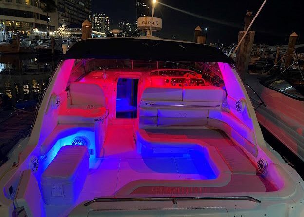 The back of a boat is lit up with red and blue lights.