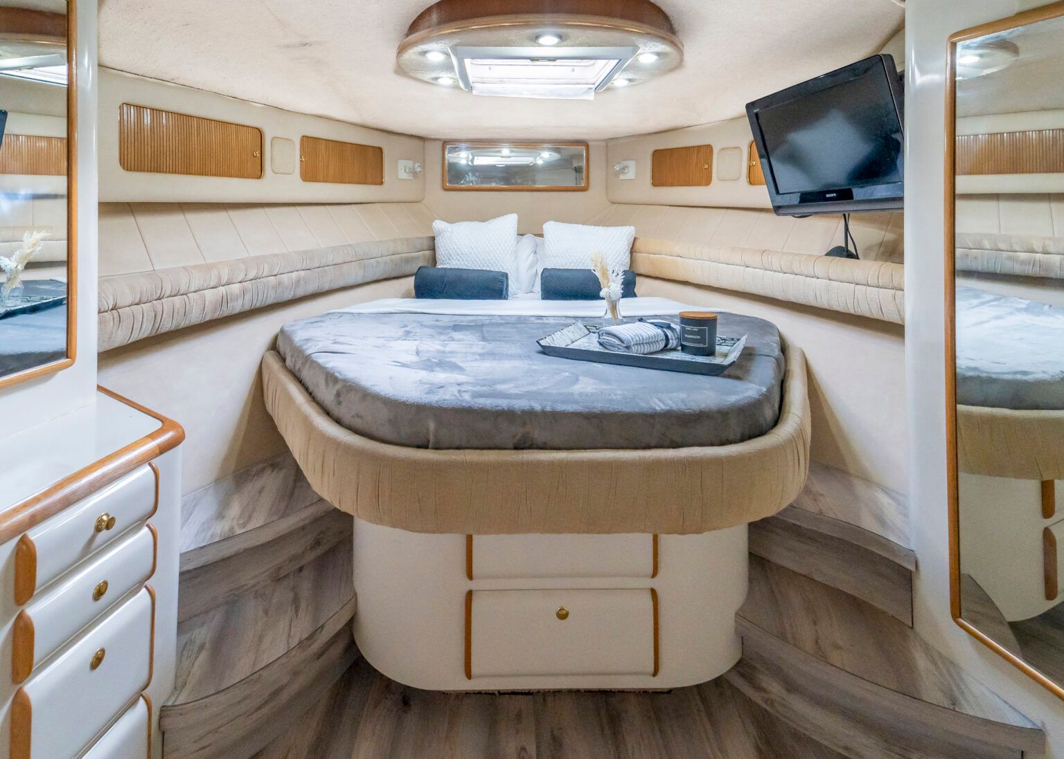 A bedroom on a boat with a bed and a television.