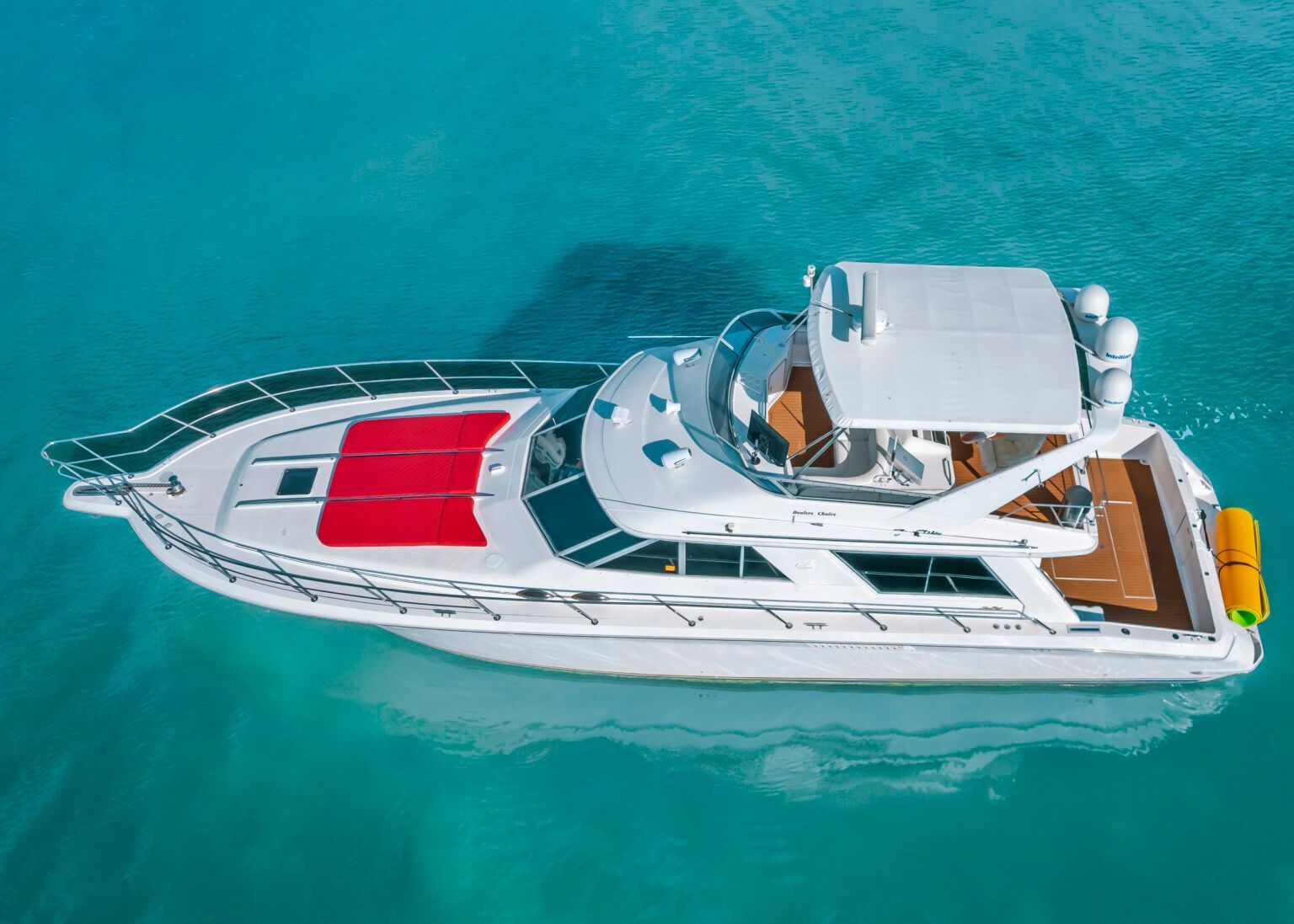 An aerial view of a white and red yacht in the ocean.