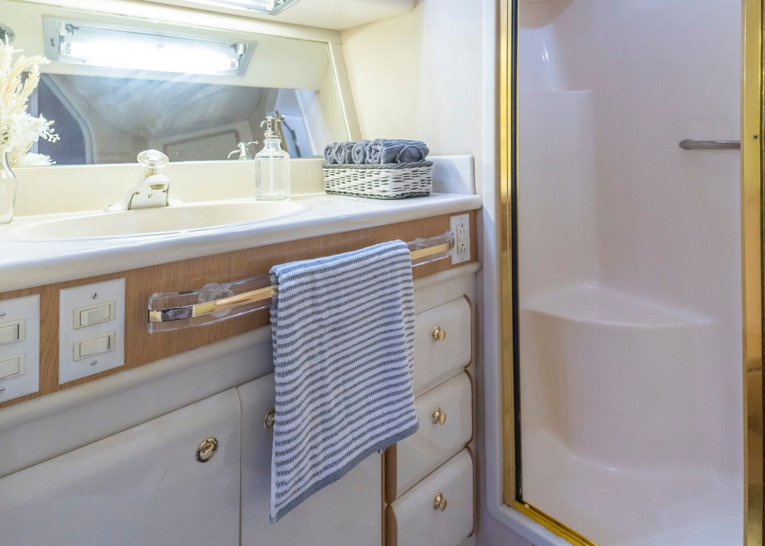 A bathroom with a sink, mirror, and shower.