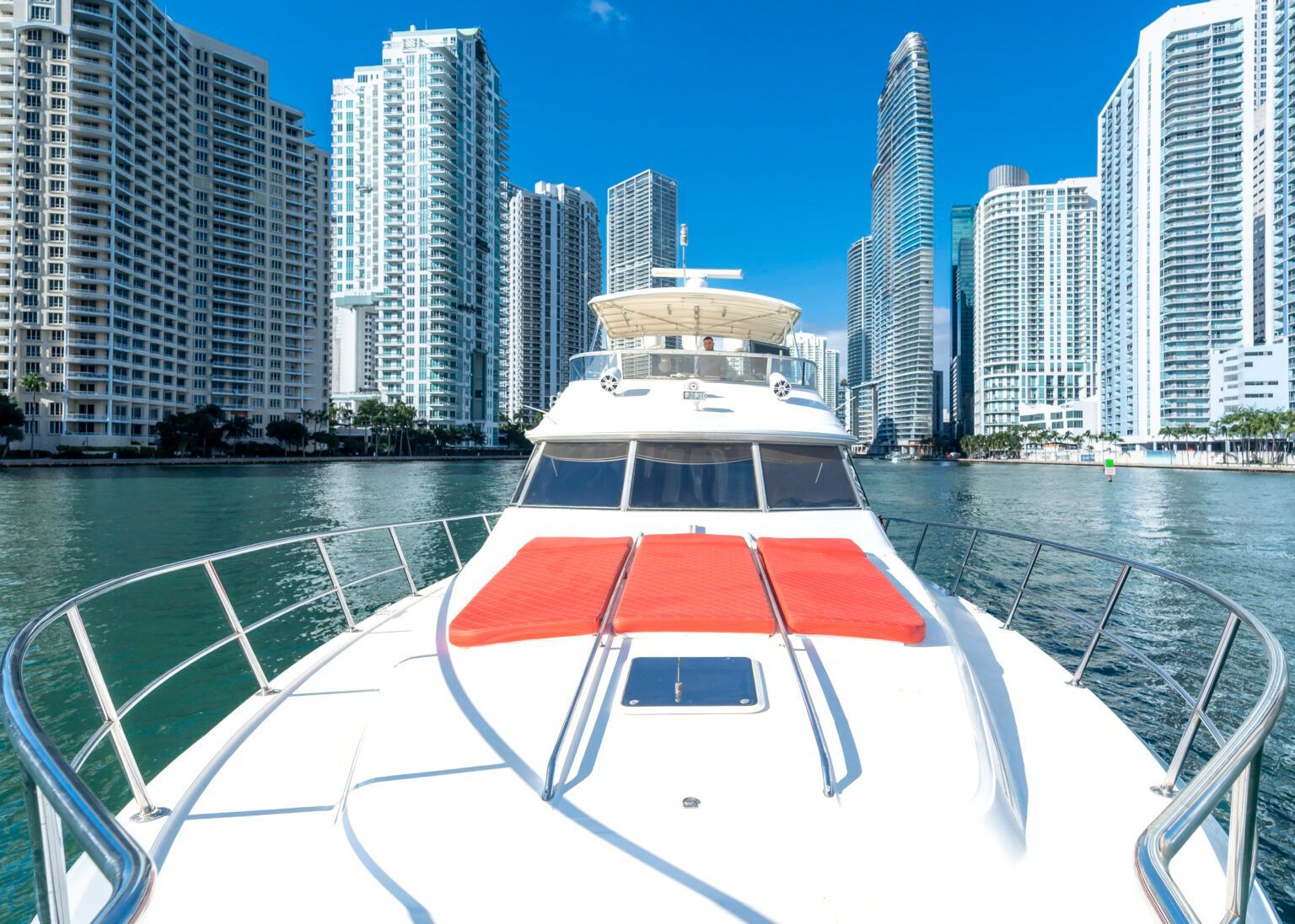 The front of a boat with a city in the background.