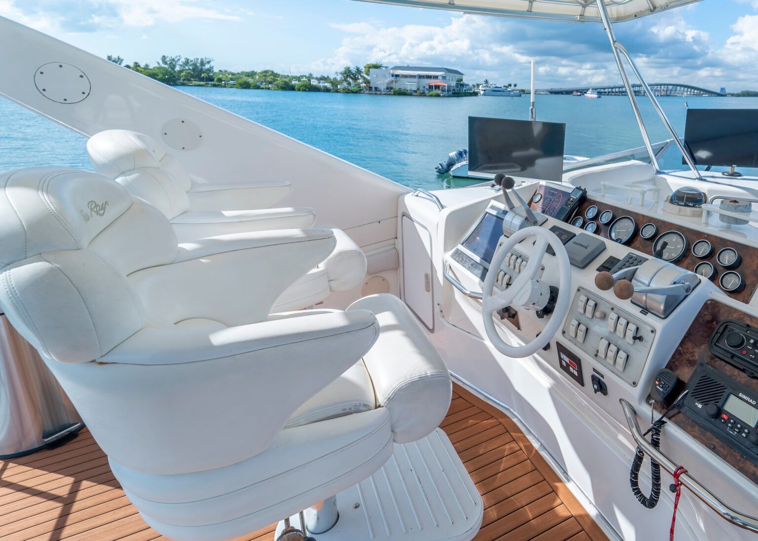 A white chair is sitting in the cockpit of a boat.