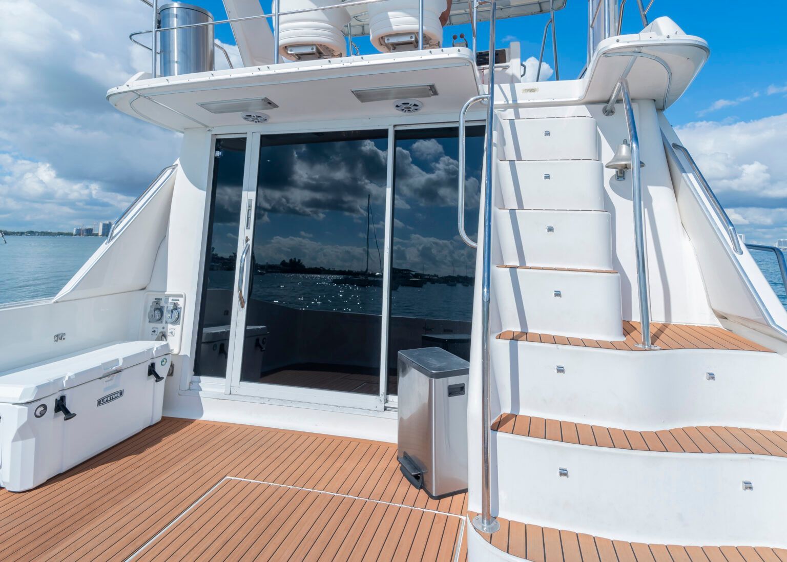 A boat with stairs leading up to the deck and a bench.