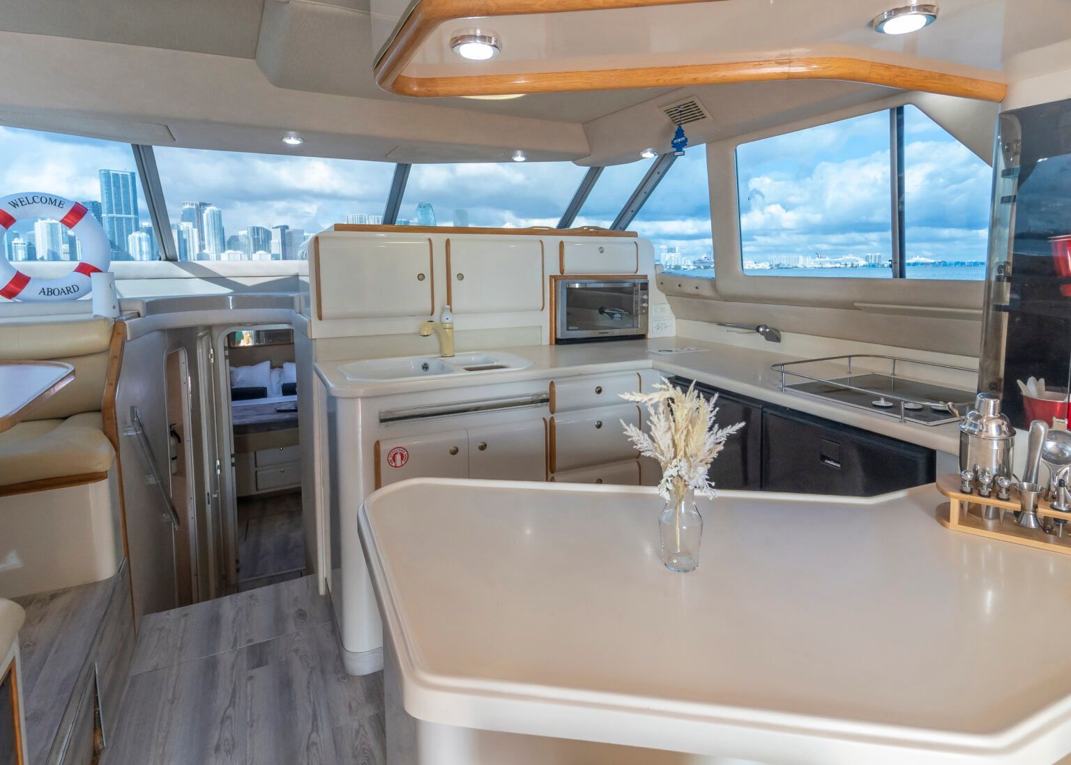 A kitchen on a boat with a vase of flowers on the counter.