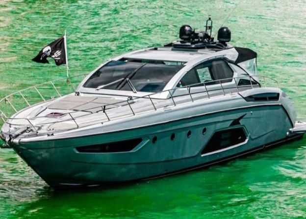 A large yacht is floating on top of a green body of water.