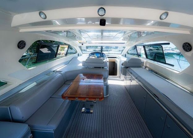 The inside of a boat with a table and chairs.