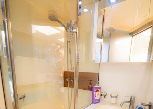 A bathroom with a sink, shower, and mirror.