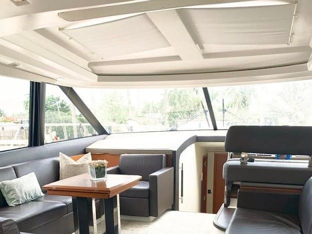 A living room on a boat with a table and chairs.