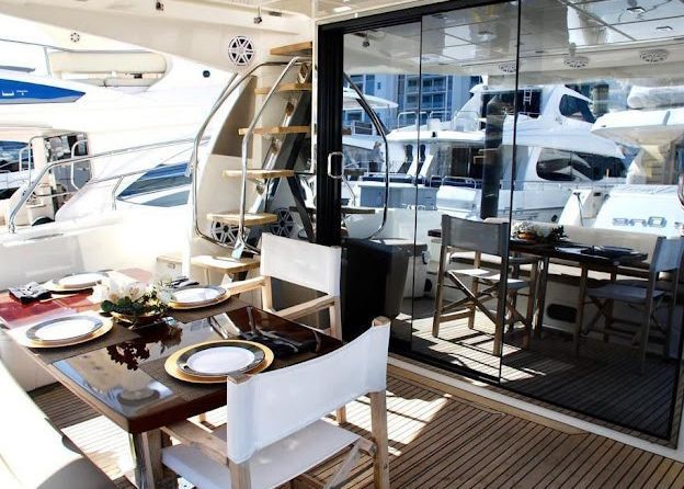 A table and chairs on the deck of a boat.