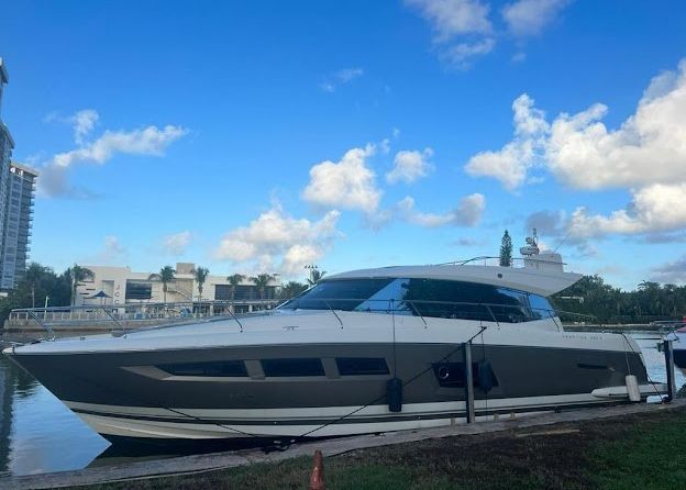 A large yacht is docked at a marina on a sunny day.