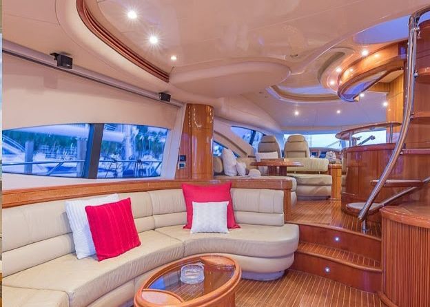 A living room on a yacht with a couch, table and stairs.