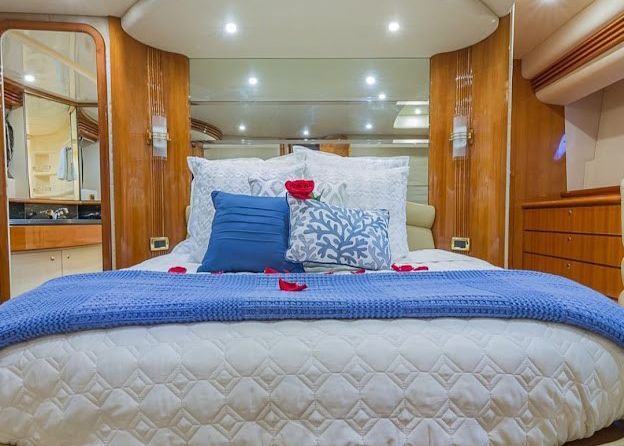 A bedroom on a boat with a bed and pillows.